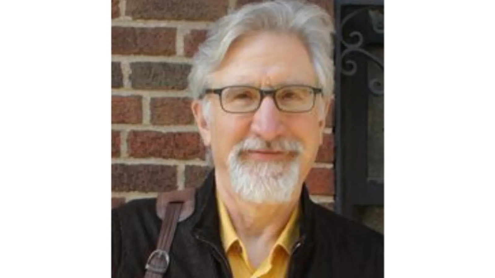 Professor Block standing by a brick wall