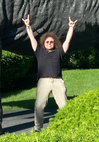 Charles Crumpler looking exuberant in front of a dinosaur